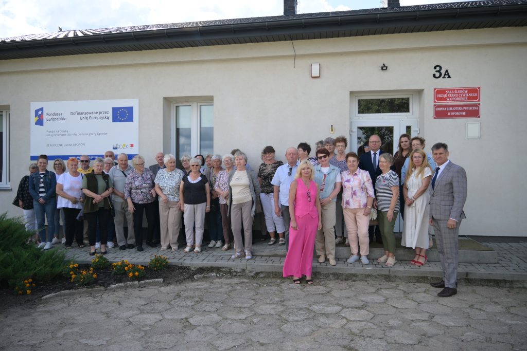 Grupa seniorów i przedstawicieli władz gminy podczas uroczystego otwarcia Klubu Seniora w Oporowie